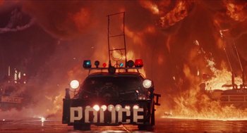 Movie still from “Super Mario Bros.” (1993), directed by Annabel Jankel – A police car is on fire in the middle of the street; Wide shot, Low angle
