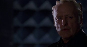 Movie still from “Super Mario Bros.” (1993), directed by Annabel Jankel – An old man with a bald head is looking at the camera; Close Up shot, Low angle