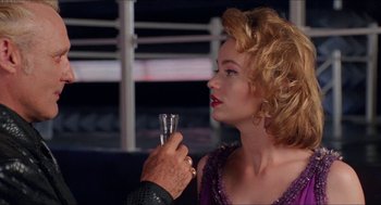 Movie still from “Super Mario Bros.” (1993), directed by Annabel Jankel – A woman holding a glass of water and a man holding a glass; Close Up shot, Over the shoulder angle
