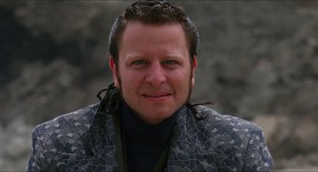 Movie still from “Super Mario Bros.” (1993), directed by Annabel Jankel – A man with long black hair and a black shirt; Close Up shot, Low angle