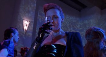 Movie still from “Super Mario Bros.” (1993), directed by Annabel Jankel – A woman in a black outfit holding a glass; Close Up shot, Low angle