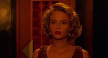 Movie still from “Super Mario Bros.” (1993), directed by Annabel Jankel – A beautiful young woman with blonde curly hair and red lipstick; Close Up shot, Low angle