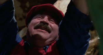 Movie still from “Super Mario Bros.” (1993), directed by Annabel Jankel – A person with a mustache wearing a hat; Close Up shot, Low angle