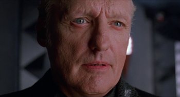 Movie still from “Super Mario Bros.” (1993), directed by Annabel Jankel – An older man with a goatee looking at the camera; Close Up shot, Low angle