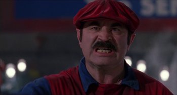 Movie still from “Super Mario Bros.” (1993), directed by Annabel Jankel – A person with a mustache wearing a hat; Close Up shot, Low angle
