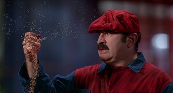 Movie still from “Super Mario Bros.” (1993), directed by Annabel Jankel – A man wearing a red hat and a red tie; Extreme Close Up shot, Low angle