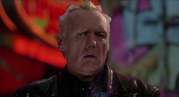 Movie still from “Super Mario Bros.” (1993), directed by Annabel Jankel – An older man with a strange look on his face; Close Up shot, Low angle