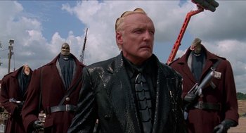 Movie still from “Super Mario Bros.” (1993), directed by Annabel Jankel – A group of people standing next to each other wearing costumes; Medium shot, Low angle