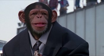 Movie still from “Super Mario Bros.” (1993), directed by Annabel Jankel – A man in a suit and tie with a monkey head; Close Up shot, Low angle