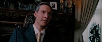 Movie still from “Surrogates” (2009), directed by Jonathan Mostow – A man wearing a suit and tie in a room; Close Up shot, Low angle