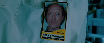 Movie still from “Surrogates” (2009), directed by Jonathan Mostow – A photo of a person with a name tag; Extreme Close Up shot, Overhead angle