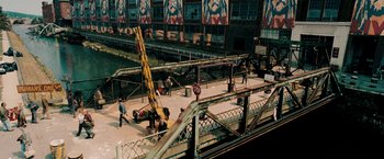 Movie still from “Surrogates” (2009), directed by Jonathan Mostow – A man standing next to a crane on top of a bridge; Extreme Wide shot, High angle