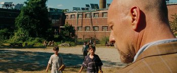 Movie still from “Surrogates” (2009), directed by Jonathan Mostow – A group of people playing baseball in a field; Wide shot, Over the shoulder angle