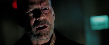 Movie still from “Surrogates” (2009), directed by Jonathan Mostow – An older man with a bruised eye and a beard; Close Up shot, Over the shoulder angle