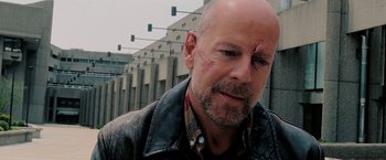 Movie still from “Surrogates” (2009), directed by Jonathan Mostow – A man with a shaved head and a leather jacket; Close Up shot, Over the shoulder angle