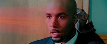 Movie still from “Surrogates” (2009), directed by Jonathan Mostow – A man in a business suit with red lines coming out of his face; Extreme Close Up shot, Overhead angle