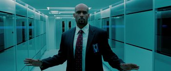 Movie still from “Surrogates” (2009), directed by Jonathan Mostow – A man in a suit and tie in an elevator; Medium shot, Low angle