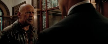 Movie still from “Surrogates” (2009), directed by Jonathan Mostow – A man in a suit and tie looking at another man in a suit and tie in front of a mirror; Close Up shot, Over the shoulder angle