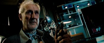 Movie still from “Surrogates” (2009), directed by Jonathan Mostow – An older man holding a cell phone in front of a microphone; Close Up shot, Low angle