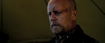 Movie still from “Surrogates” (2009), directed by Jonathan Mostow – A bald man with a scar on his face; Close Up shot, Low angle