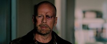 Movie still from “Surrogates” (2009), directed by Jonathan Mostow – A bald man with a goatee is looking at the camera; Close Up shot, Over the shoulder angle