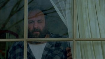 Movie still from “Surviving Christmas” (2004), directed by Mike Mitchell – A man looking out of a window with a beard; Close Up shot, Low angle