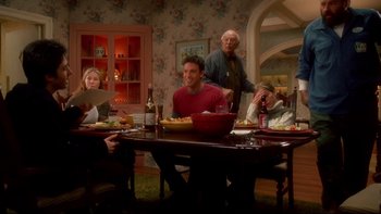 Movie still from “Surviving Christmas” (2004), directed by Mike Mitchell – A group of people sitting at a table with plates of food on it; Wide shot, High angle