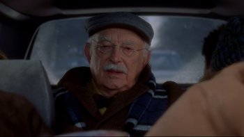 Movie still from “Surviving Christmas” (2004), directed by Mike Mitchell – An old man sitting in the back seat of a car; Close Up shot, Over the shoulder angle