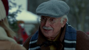 Movie still from “Surviving Christmas” (2004), directed by Mike Mitchell – An old man wearing glasses and a hat; Close Up shot, Over the shoulder angle