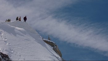 Movie still from “Surviving Christmas” (2004), directed by Mike Mitchell – A person standing on top of a snow covered slope; Extreme Wide shot, Low angle