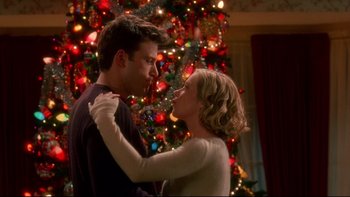 Movie still from “Surviving Christmas” (2004), directed by Mike Mitchell – A man and a woman standing in front of a christmas tree; Medium shot, Low angle