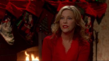 Movie still from “Surviving Christmas” (2004), directed by Mike Mitchell – A woman in a red shirt sitting in front of a fireplace; Close Up shot, Over the shoulder angle