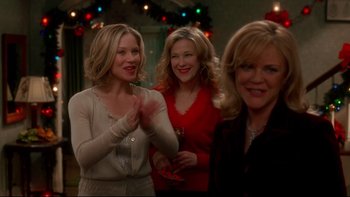 Movie still from “Surviving Christmas” (2004), directed by Mike Mitchell – A group of women standing next to each other in a room; Medium shot, Over the shoulder angle