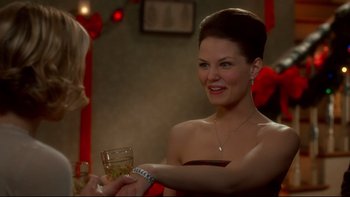 Movie still from “Surviving Christmas” (2004), directed by Mike Mitchell – A beautiful woman holding a wine glass in a room; Close Up shot, Over the shoulder angle