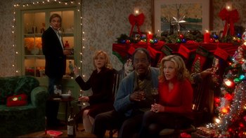 Movie still from “Surviving Christmas” (2004), directed by Mike Mitchell – A group of people sitting in a living room; Wide shot, High angle