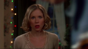 Movie still from “Surviving Christmas” (2004), directed by Mike Mitchell – A woman with short blonde hair is looking at the camera; Close Up shot, Over the shoulder angle