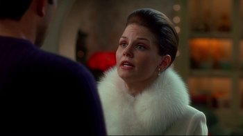 Movie still from “Surviving Christmas” (2004), directed by Mike Mitchell – A woman wearing a white fur coat and earrings; Close Up shot, Over the shoulder angle