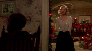Movie still from “Surviving Christmas” (2004), directed by Mike Mitchell – A woman standing in front of a christmas tree in a room; Medium shot, Over the shoulder angle