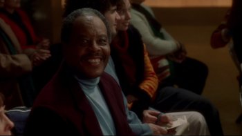 Movie still from “Surviving Christmas” (2004), directed by Mike Mitchell – An older man smiles while holding a wii controller; Close Up shot, High angle