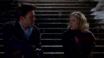 Movie still from “Surviving Christmas” (2004), directed by Mike Mitchell – A man and a woman sitting next to each other on steps; Medium shot, High angle