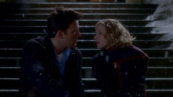 Movie still from “Surviving Christmas” (2004), directed by Mike Mitchell – A man and a woman sitting next to each other on some steps; Medium shot, High angle