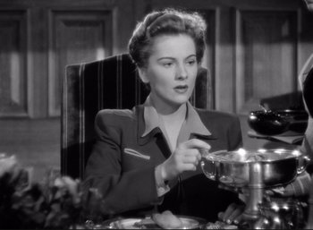 Movie still from “Suspicion” (1941), directed by Alfred Hitchcock – A woman sitting at a table with a bowl in front of her; Close Up shot, Low angle