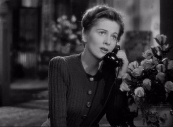 Movie still from “Suspicion” (1941), directed by Alfred Hitchcock – A woman talking on a phone while sitting down; Close Up shot, High angle