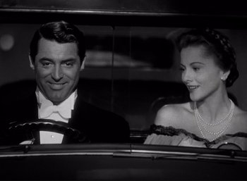 Movie still from “Suspicion” (1941), directed by Alfred Hitchcock – A black and white photo of a man and a woman in the backseat of a car; Medium shot, Low angle