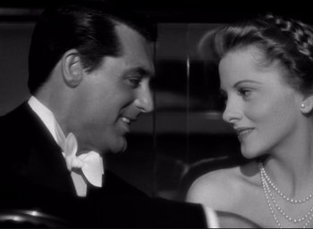 Movie still from “Suspicion” (1941), directed by Alfred Hitchcock – A man and a woman smiling at each other in front of a mirror; Close Up shot, Low angle