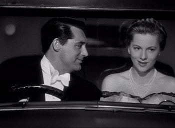 Movie still from “Suspicion” (1941), directed by Alfred Hitchcock – A man and a woman sitting in the back of a car; Medium shot, Low angle