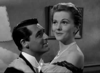 Movie still from “Suspicion” (1941), directed by Alfred Hitchcock – A man and a woman are posing for a picture; Close Up shot, Low angle