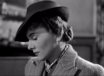 Movie still from “Suspicion” (1941), directed by Alfred Hitchcock – A woman wearing a hat and a sweater; Close Up shot, Low angle