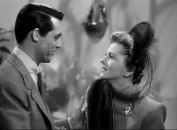 Movie still from “Suspicion” (1941), directed by Alfred Hitchcock – A man and a woman smiling at each other in a room; Close Up shot, Over the shoulder angle
