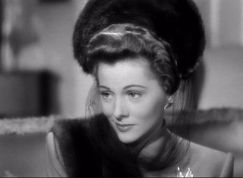 Movie still from “Suspicion” (1941), directed by Alfred Hitchcock – A black and white photo of a woman with a fur hat; Close Up shot, Over the shoulder angle